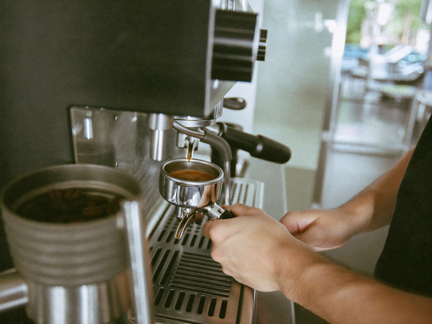 Barista che aggancia il portafiltro alla macchina espresso